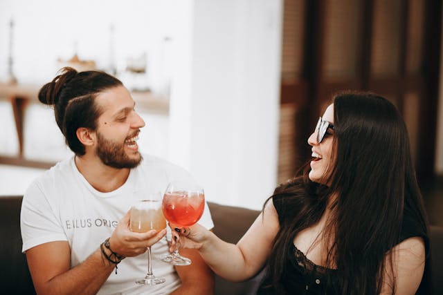 Due ex brindano sorridendo durante una conversazione leggera e spontanea.