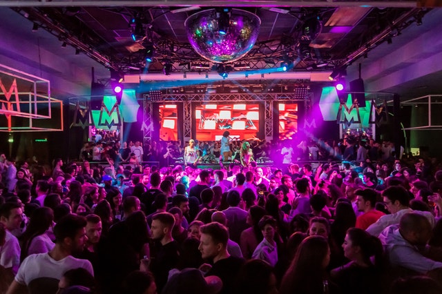 Un pubblico si diverte a un concerto, simbolo di un ex che riprende in mano la propria vita dopo la rottura.