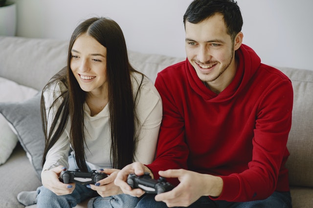 Un uomo e una donna giocano insieme ai videogiochi come amici.