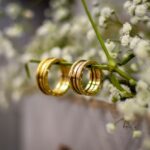 Due fedi nuziali su un ramo fiorito, simbolo di una seconda possibilità per il matrimonio.