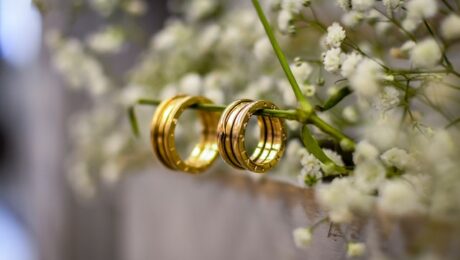 Due fedi nuziali su un ramo fiorito, simbolo di una seconda possibilità per il matrimonio.