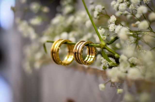 Due fedi nuziali su un ramo fiorito, simbolo di una seconda possibilità per il matrimonio.