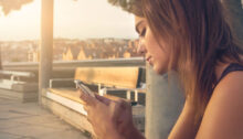 Una donna guarda il telefono delusa perché l’ex non risponde ai suoi messaggi o alle sue chiamate.
